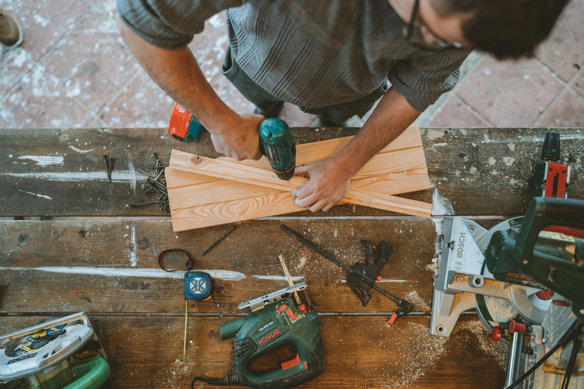person doing home improvement, drilling shelf
