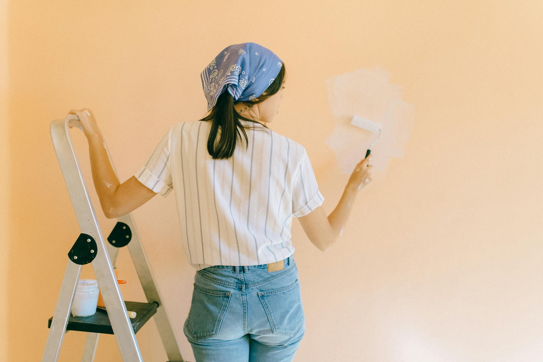 woman painting wall living room