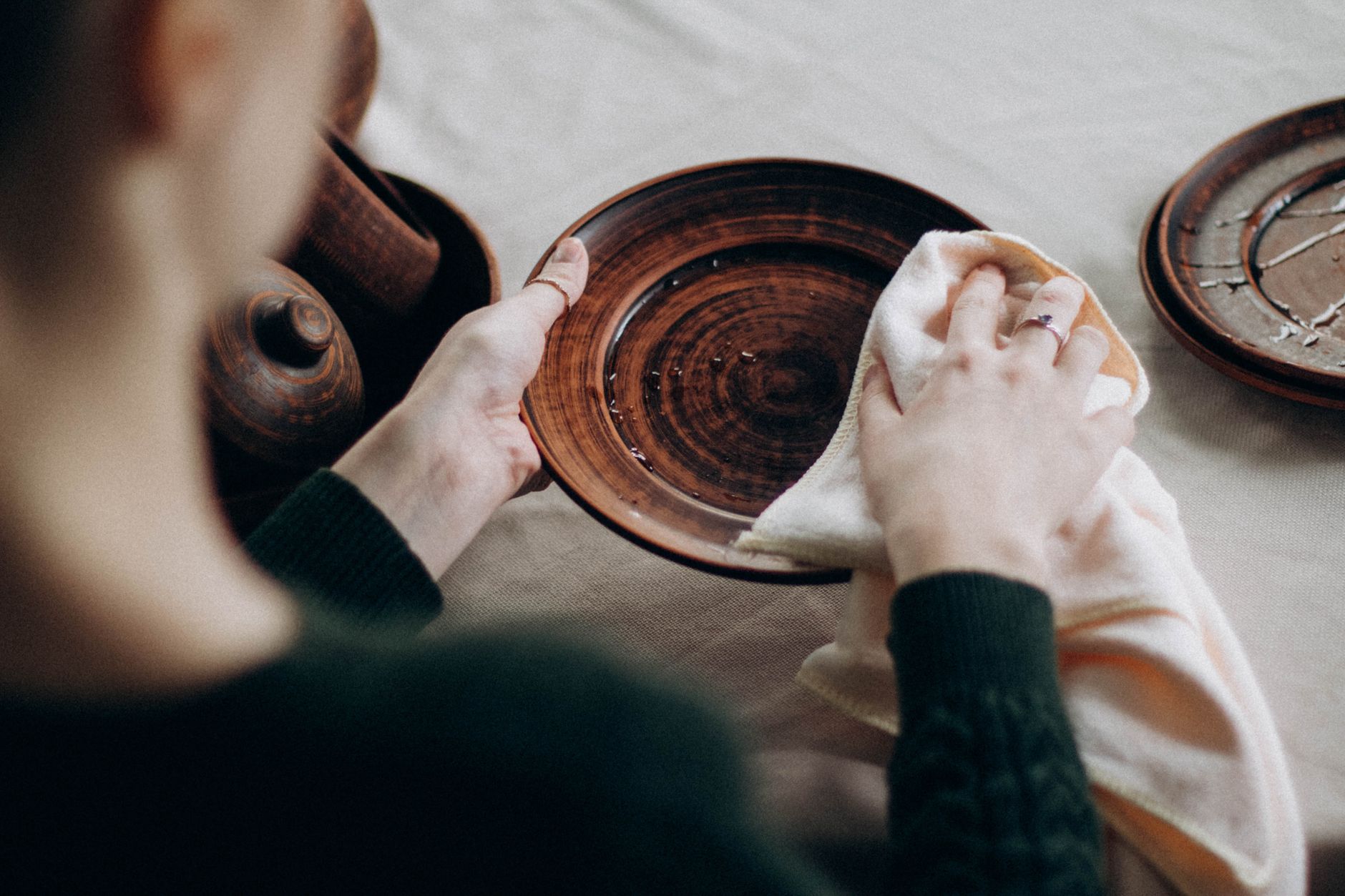 person cleaning wooden table